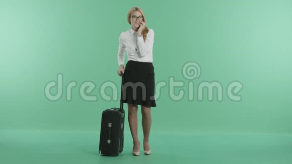 一个女人拿着行李打电话视频的预览图