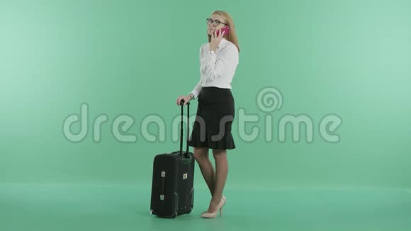 一个金发女人站在手提箱附近打电话视频的预览图