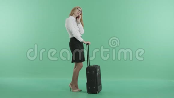 一个好女人拿着行李在电话里说话视频的预览图