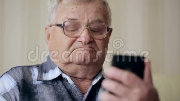 老人通过手机在沙发上发短信视频的预览图