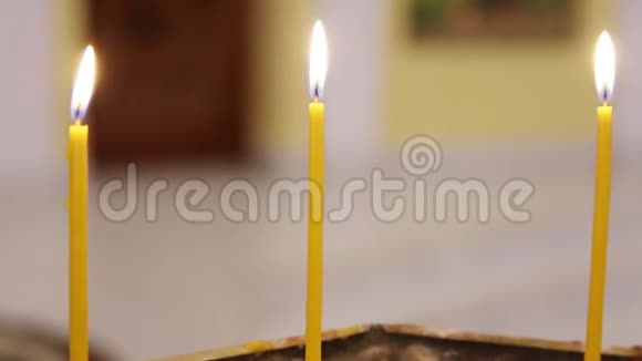 在一个宗教节日里蜡烛在寺庙里燃烧在暮色中点燃寺庙里的蜡烛视频的预览图