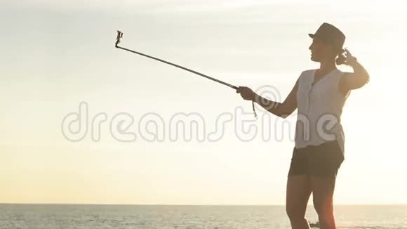 一位漂亮的女士在自拍棒上用动作摄像机拍摄自己的视频视频的预览图