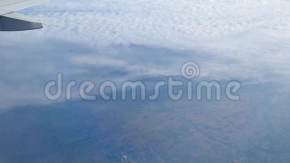 乘飞机旅行鸟透过飞机窗的视野飞越中国城市房屋和街道云下的城市视频的预览图