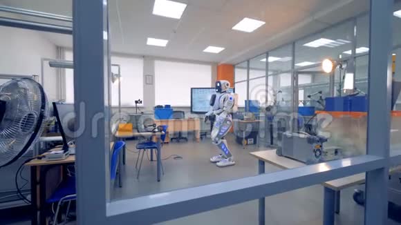 一个白色机器人站在房间里视频的预览图