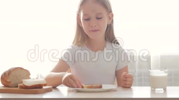 孩子喝牛奶吃三明治一个拿着三明治的女孩正在品尝视频的预览图