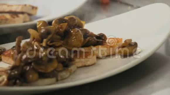 厨师准备了一道菜里面放着蘑菇放在白盘烤鱼上视频的预览图
