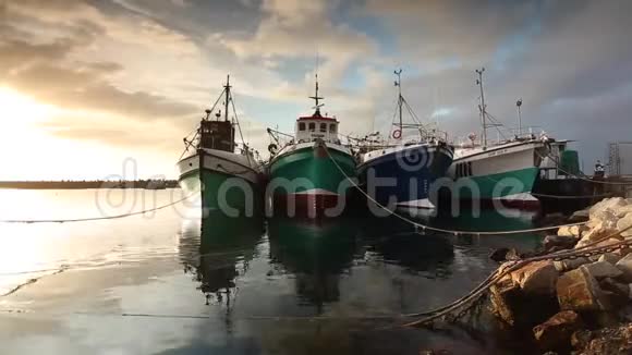 美丽的视频画面渔船停泊在甘斯巴伊港与美丽的日落在奥伯格地区的南非视频的预览图