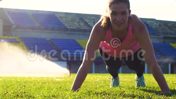 健身女性在草地上做俯卧撑视频的预览图