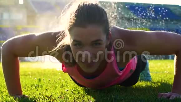 健身女性在草地上做俯卧撑视频的预览图