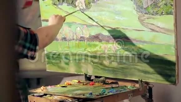 艺术家用调色板在手中画一幅油画投中弹视频的预览图