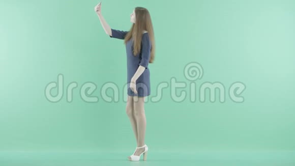 一个穿着衣服的女孩站着做自拍视频的预览图