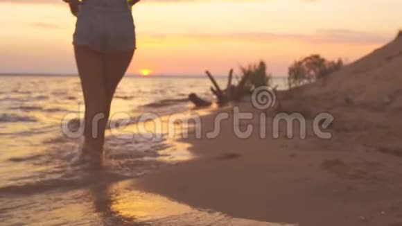 海滩上的一个年轻女孩在电话里拍照视频的预览图