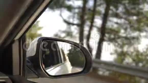 查看后视镜当汽车在夏天沿着道路行驶时4k慢镜头拍摄视频的预览图