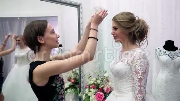 伴娘帮助未来的新娘选择婚纱准备结婚的年轻女子视频的预览图