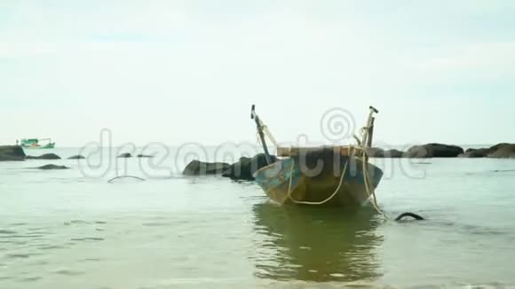 越南船船在渔村的波浪上摇动这艘小型传统渔船在海岸的费用视频的预览图