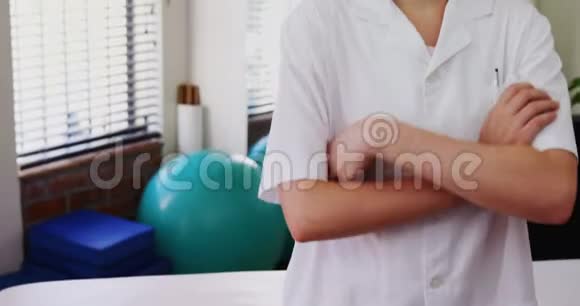 女子物理治疗师站在诊所交叉双臂4k视频的预览图