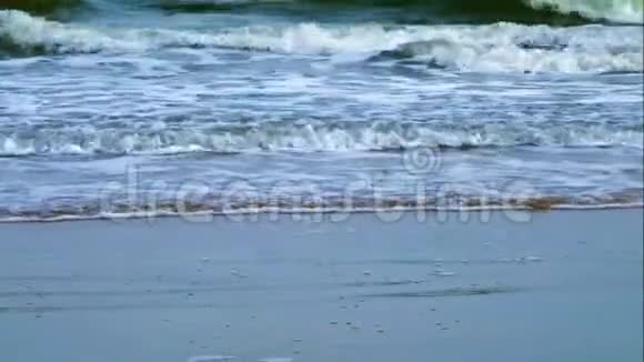 沙滩上的沙滩海浪轻轻地向岸边翻滚视频的预览图