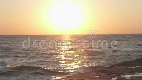 那个女孩在码头上的海面上迎接黎明日出和日出背景下女孩的剪影视频的预览图