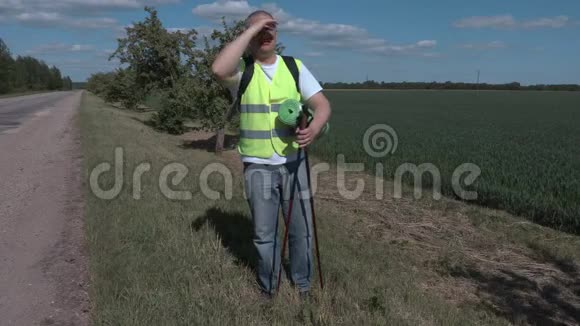 徒步旅行者在田边用登山杖视频的预览图