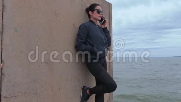 女人在海边码头打电话视频的预览图