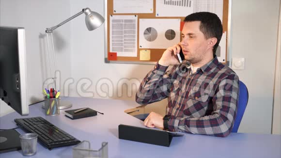 办公室工作人员在手机上和他的客户坐在他的办公室里视频的预览图