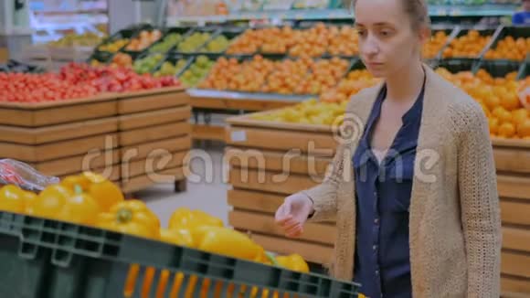 在杂货店买新鲜橘子甜椒的女人视频的预览图