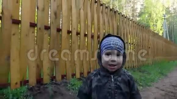 可爱的小男孩在公园的乡村道路上散步玩得很开心玩棍子视频的预览图