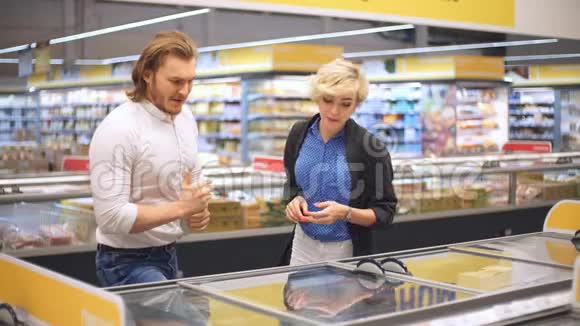 快乐的白种人夫妇在购物中心的杂货店选择冷冻食品视频的预览图