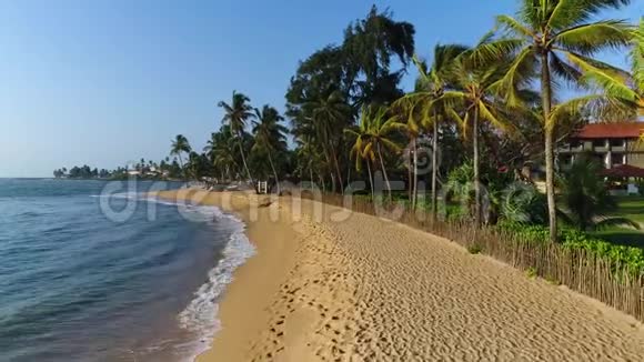 斯里兰卡海上海浪沙滩和木制围栏后面的度假屋视频的预览图