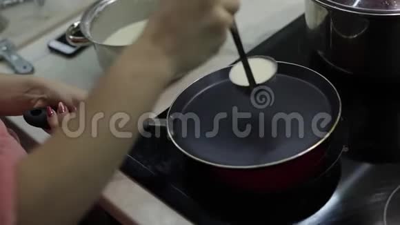 烹饪自制煎饼的过程女人往锅里倒煎饼面团视频的预览图