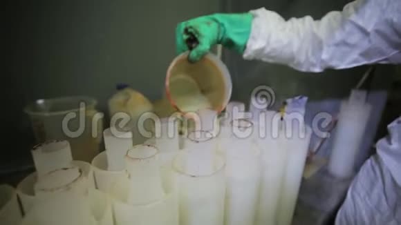 一排排塑料滤水器正被烧杯装满白色液体视频的预览图
