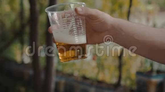 手拿手慢摇轻啤酒透明塑料杯视频的预览图