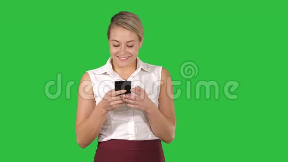 商务女士在绿色屏幕上行走时发短信Chroma键视频的预览图