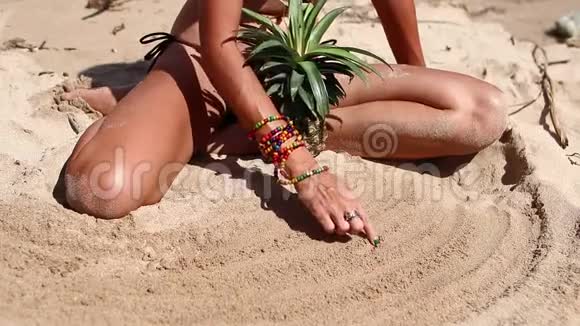 穿着棕色泳衣的女人在海滩上菠萝在沙滩上画画年轻女性正在享受暑假视频的预览图