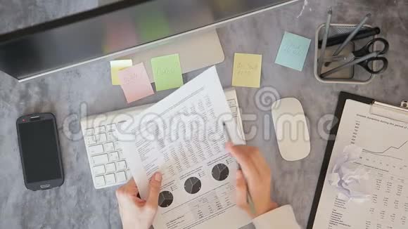 女员工拿着文件图表用铅笔做笔记坐在办公室打电话视频的预览图