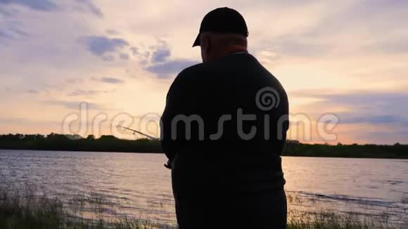 剪影渔夫在黎明时在河里扔了一个渔具视频的预览图