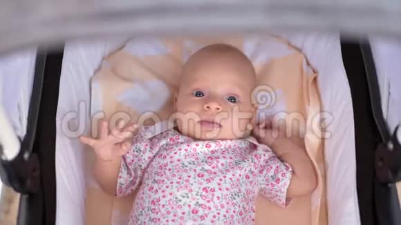三个月的小女孩躺在婴儿车里视频的预览图