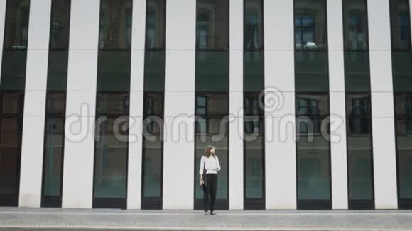 以现代建筑为背景站在柏林街头的女性视频的预览图