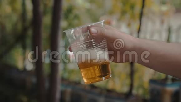 手拿手慢摇轻啤酒透明塑料杯视频的预览图