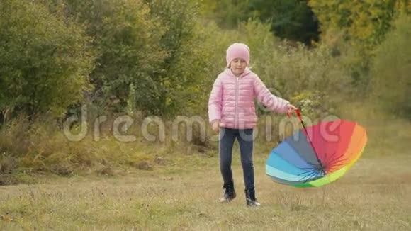 小女孩在玩一把五颜六色的伞视频的预览图