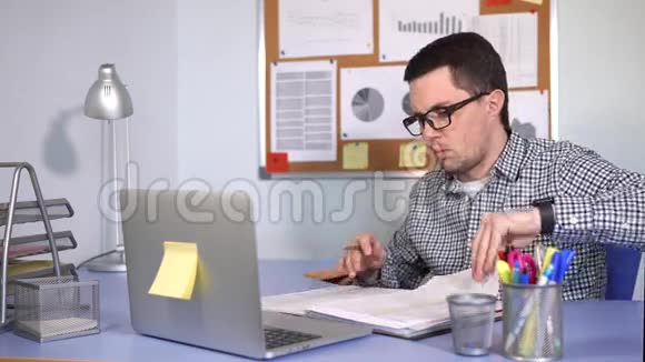 主任检查电脑桌上的文件视频的预览图