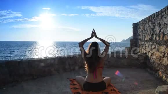 穿着泳衣的女孩在大海和太阳前结束冥想视频的预览图