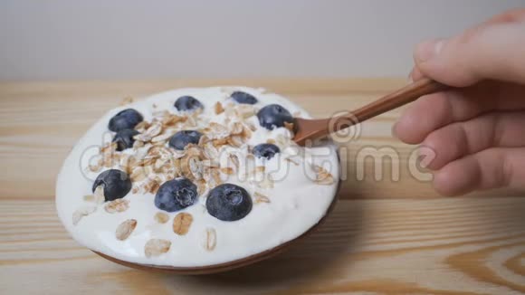 吃蓝莓与奶油或酸奶和月桂用勺子视频的预览图