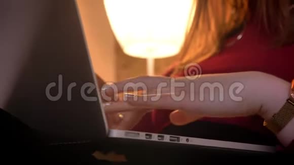 在室内一间舒适的公寓里女性手在笔记本电脑上打字的特写镜头视频的预览图