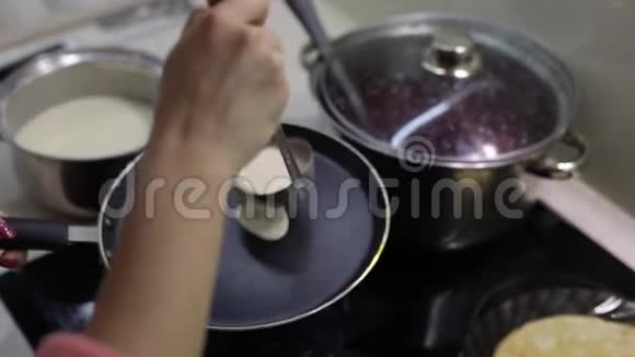 烹饪自制煎饼的过程女人往锅里倒煎饼面团视频的预览图