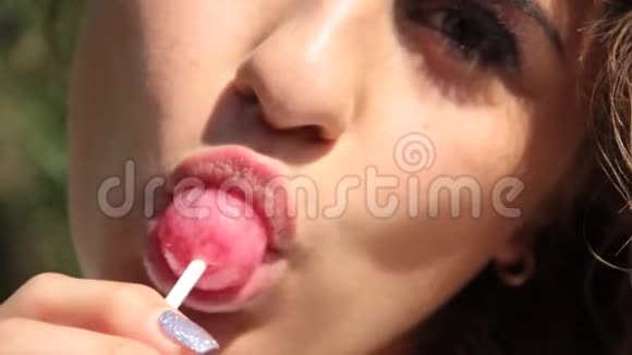 美丽的女孩带着糖果时髦的夏日欢快迷人的卷发视频的预览图