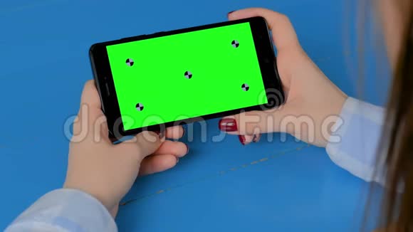 女人看黑色智能手机与空绿色屏幕色度关键概念视频的预览图
