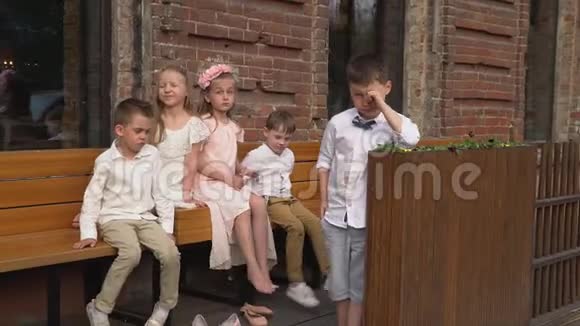 孩子们穿着复古的衣服在镜头前的长凳上视频的预览图