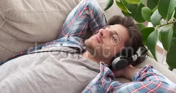 放松的男人在耳机上听音乐视频的预览图