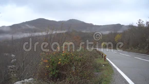 秋天潮湿的山路开着一辆黑色的车视频的预览图